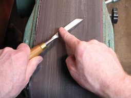 Sharpening a carving tool with a flat edge on the horizontal belt sander Sharpening a carving tool with a flat edge on the horizontal belt sander